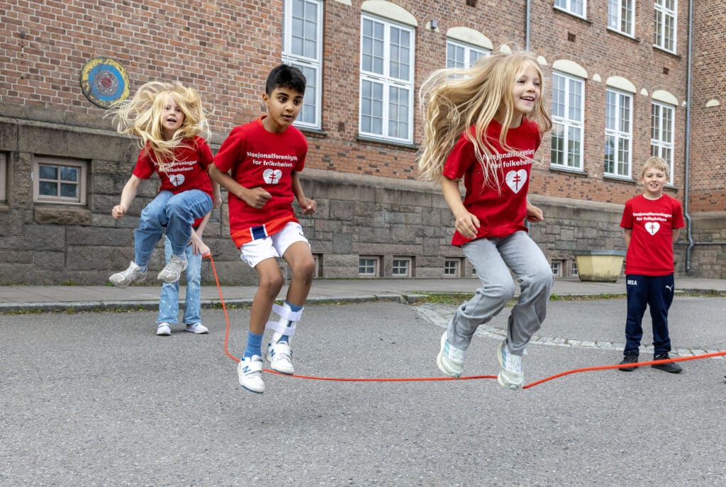 Elever som hopper tau i en skolegård