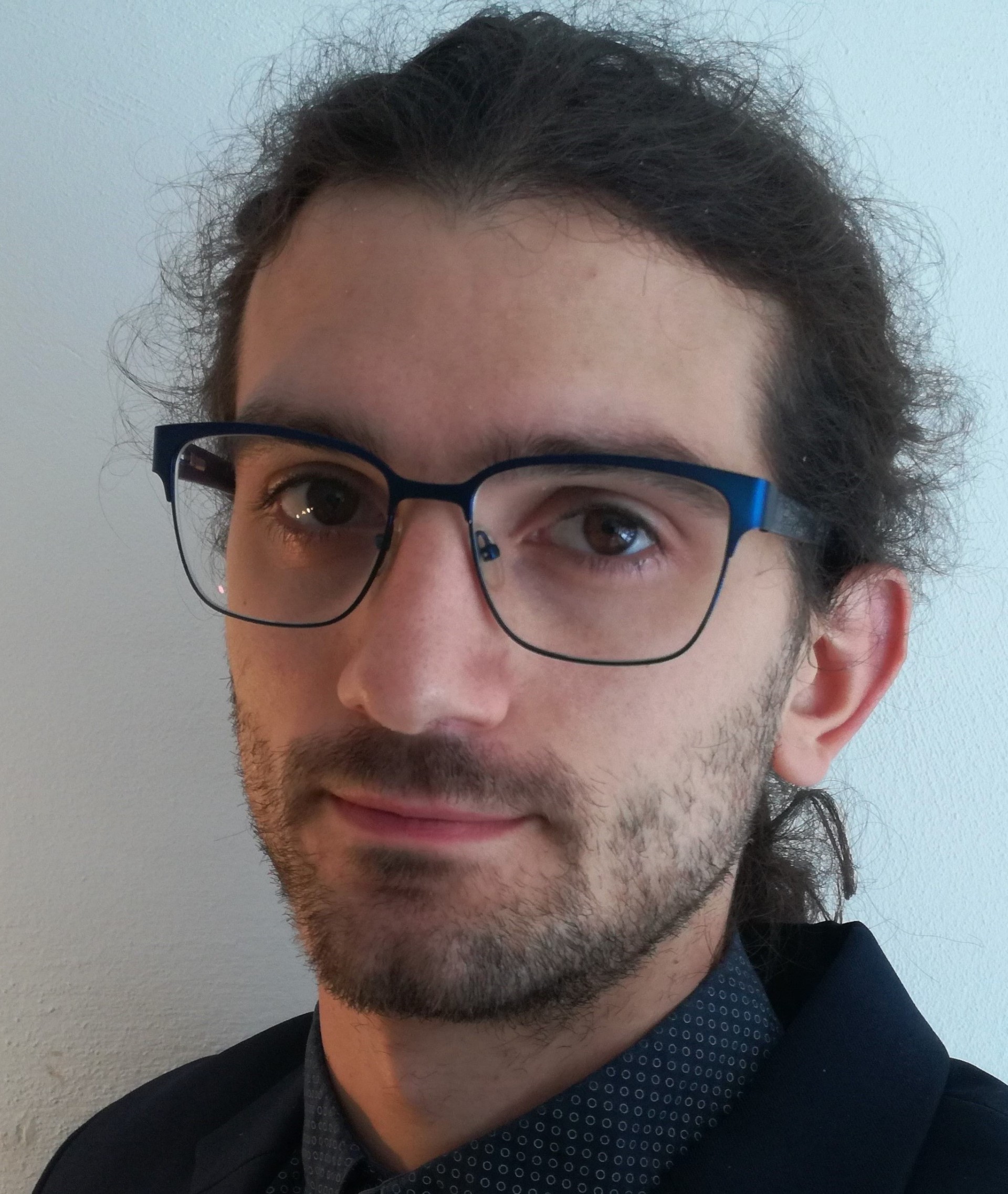 Bilde av en mann med briller, han smiler lett