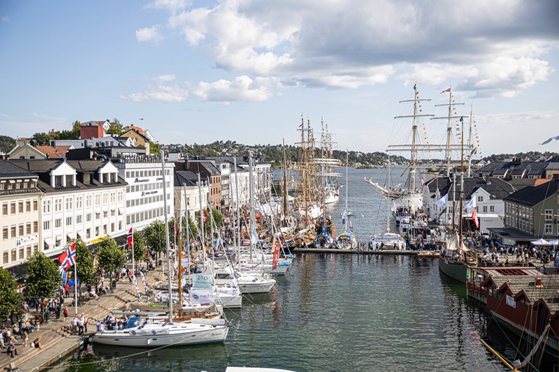 Bilde av havnen i Arendal med seilbåter og folkeliv